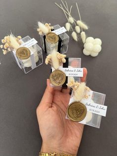 someone is holding some small plastic containers with coins in them and flowers on the table