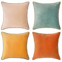 four different colored pillows on a white background