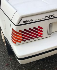 the back end of a white car with red stripes on it's tailpipe