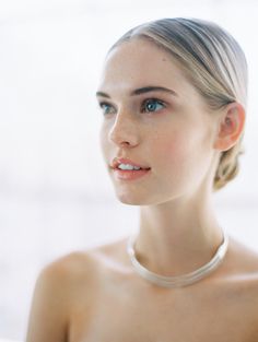 a young woman wearing a necklace and posing for the camera