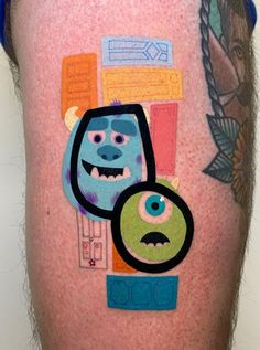 a close up of a person's leg with tattoos on it and an image of monsters