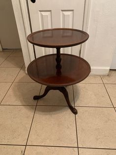 two tiered table sitting on the floor in front of a door