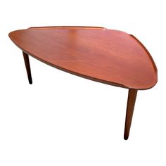 an oval shaped wooden table with two legs and a curved top, on white background