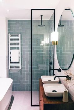 a bathroom with two sinks and a large mirror in the middle of it's wall