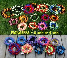 several different types of flower hair ties on a wooden deck with grass in the background