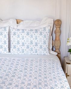 a bed with white and blue bedspread in a bedroom