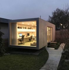 a small office in the middle of a yard with stairs leading up to it's entrance