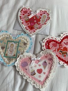 three heart shaped magnets sitting on top of a bed