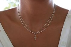 This necklace showcases a delicate 925 sterling silver cross pendant paired with a dainty chain. An ideal gift for yourself or a loved one. Please note: This listing is for one necklace only. The model in the pictures is layering multiple necklaces.   D E T A I L S   ▪ Cross measures approximately 12 mm in length ▪ Engraved 925 ▪ Italian 1 mm Box chain  ▪ 925 Sterling Silver. ▪ Fine finish   C H A I N  LE N G H T  Choose your favorite chain length! Options: 16" & 18"  S T E R L I N G  S I L V E Silver Cross Necklace With Delicate Chain, Silver Sterling Cross Necklace With Delicate Chain, Elegant Sterling Silver Cross Necklace With Delicate Chain, Minimalist Sterling Silver Cross Necklace With Clavicle Chain, Dainty Sterling Silver Cross Necklace With Clavicle Chain, Dainty Sterling Silver Cross Jewelry, Delicate Sterling Silver Cross Pendant Necklace, Dainty Sterling Silver Cross Necklace For Gift, Silver Cross Necklace With Delicate Chain For Gift