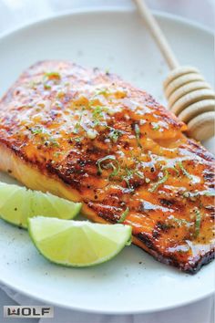 grilled salmon with lime wedges on a white plate