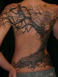 the back of a woman with tattoos on her chest and tree tattoo designs on it