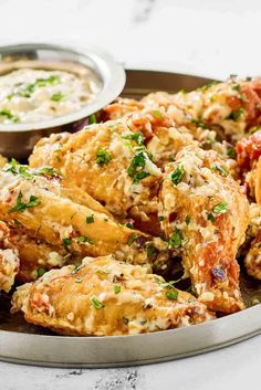 a plate full of chicken wings with dipping sauce