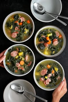 three bowls of soup with sausage, kale and carrots