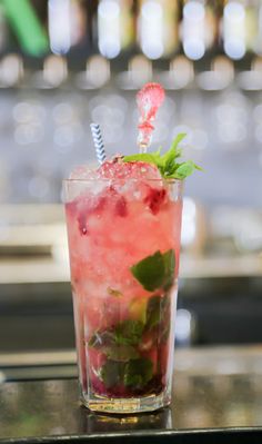 a tall glass filled with watermelon and mint garnish on top of a table