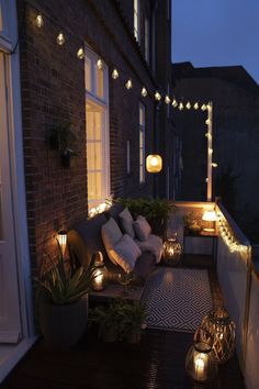 an outdoor patio with lights and potted plants