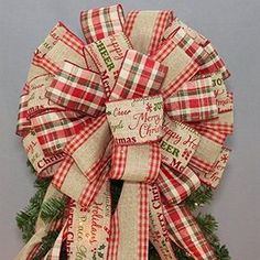 a red and white christmas tree bow hanging on a wall