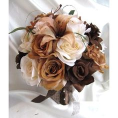 the bridal bouquet is made up of brown and white roses, foliage, and leaves