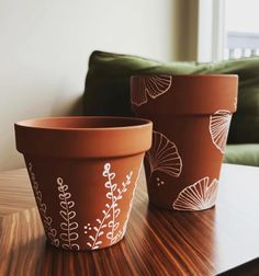 two clay pots sitting on top of a wooden table