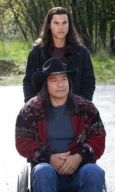 a man sitting in a wheel chair next to a woman