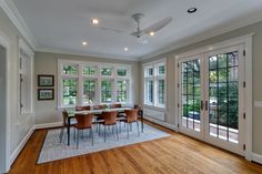 an empty dining room with wood floors and large glass doors leading to the outside patio