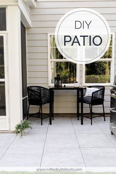 two black chairs sitting on top of a patio next to a table with a sign that says diy patio