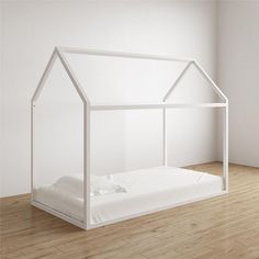 a bed with a white canopy and sheets on top of it in front of a wall