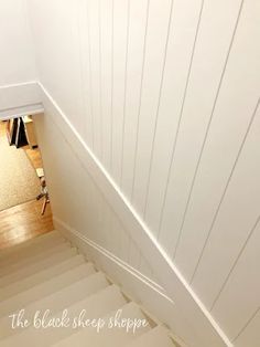 an overhead view of a staircase leading up to the second floor with white painted wood paneling