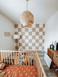 a baby's crib in the corner of a room with checkered walls