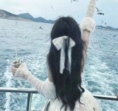 a woman on a boat with seagulls flying over her and the back of her head