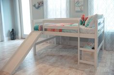 a child's bed with a slide in the middle and pillows on the bottom