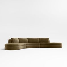 the curved sectional sofa is made from suede fabric and has a rounded backrest