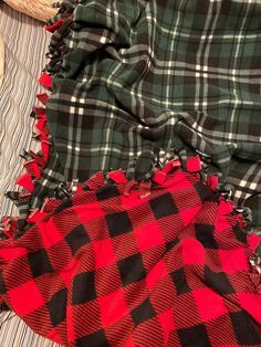 a plaid blanket laying on top of a bed next to a straw hat and pillow