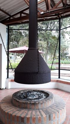 an outdoor fireplace with a chain hanging from it's centerpiece in a building