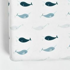 a blue whale print crib sheet with white sheets