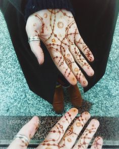 two hands that are covered in henna