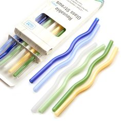 three different colored toothbrushes in a package on a white surface with the box open