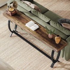 a living room with a couch, coffee table and books on the end tables in front of it