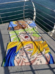 three rugs on the side of a boat with one being an anime character and another being a cartoon character