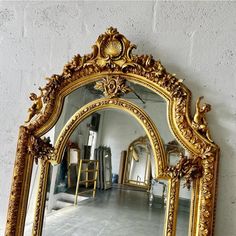 an ornate gold framed mirror on the wall