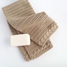 a crocheted cloth with a soap bar on the end, sitting next to it