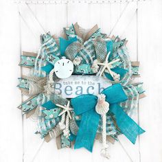 a wreath made out of burlocks and ribbons with the words take me to the beach on it