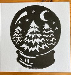 a black and white drawing of a snow globe with trees in it on a wooden table