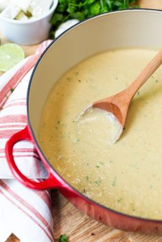 a wooden spoon in a pot filled with broccoli soup