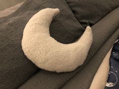 a crescent shaped pillow on top of a bed