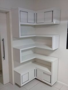 an empty room with white shelves and cupboards