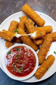 fried fish sticks on a plate with ketchup and sauce