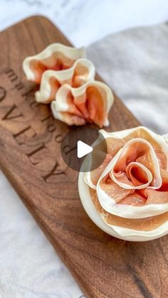 a wooden cutting board topped with food on top of a table