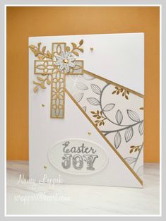 an easter card with a cross on the front and gold trimmings, decorated with leaves