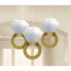 three white and gold decorations hanging from the ceiling