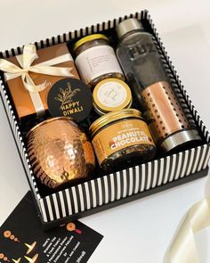 a gift box filled with different types of condiments and jams next to a card